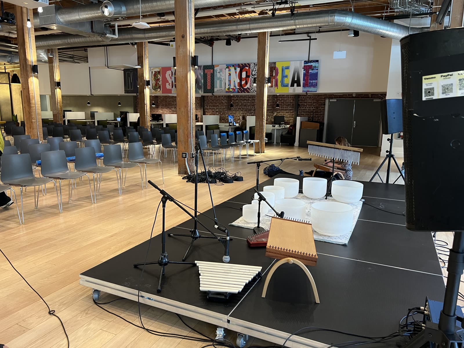 Full sound healing instrument setup on a stage in a large company event space
