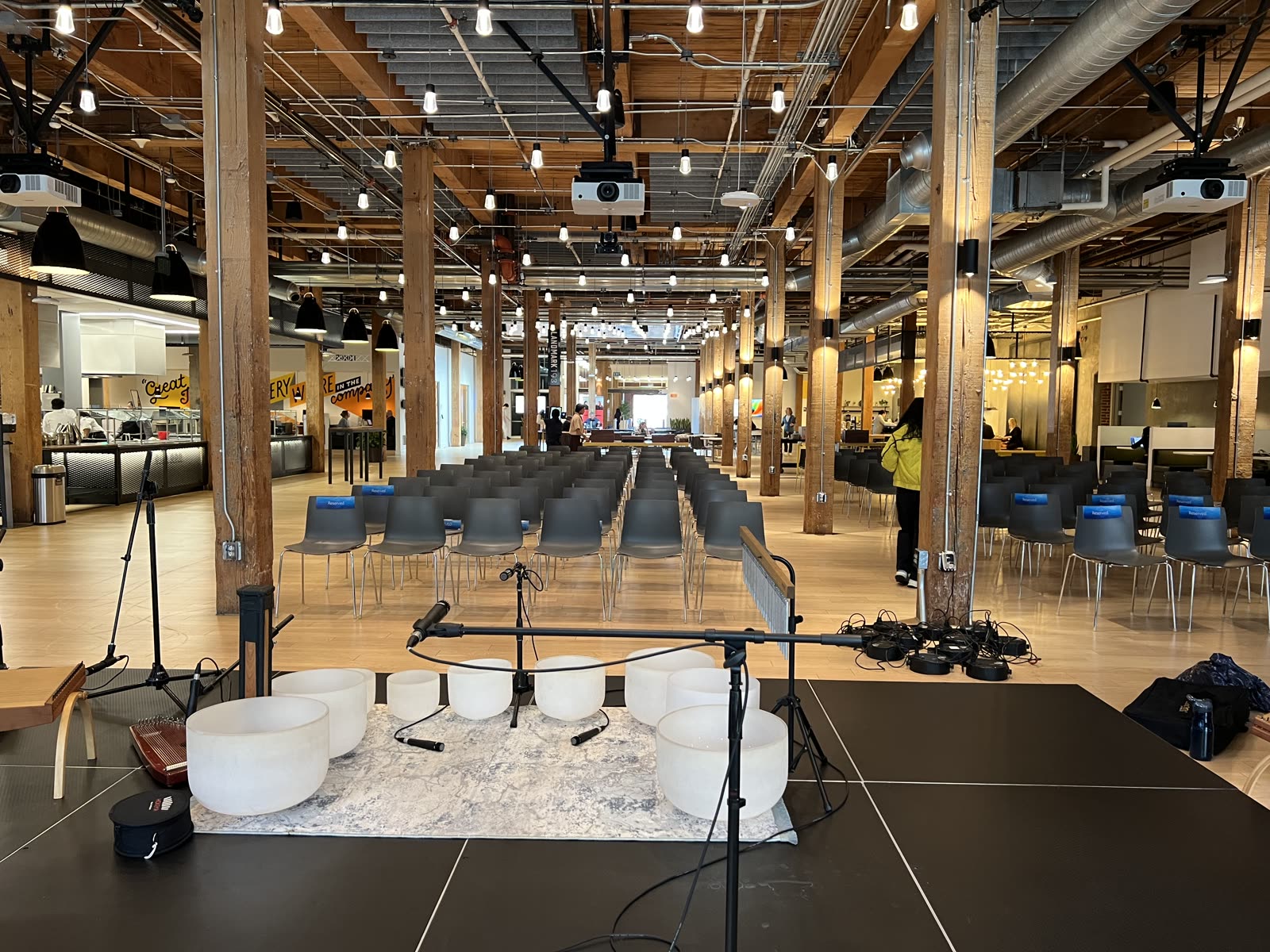 Wide view of a corporate event space with rows of chairs facing a sound bath setup
