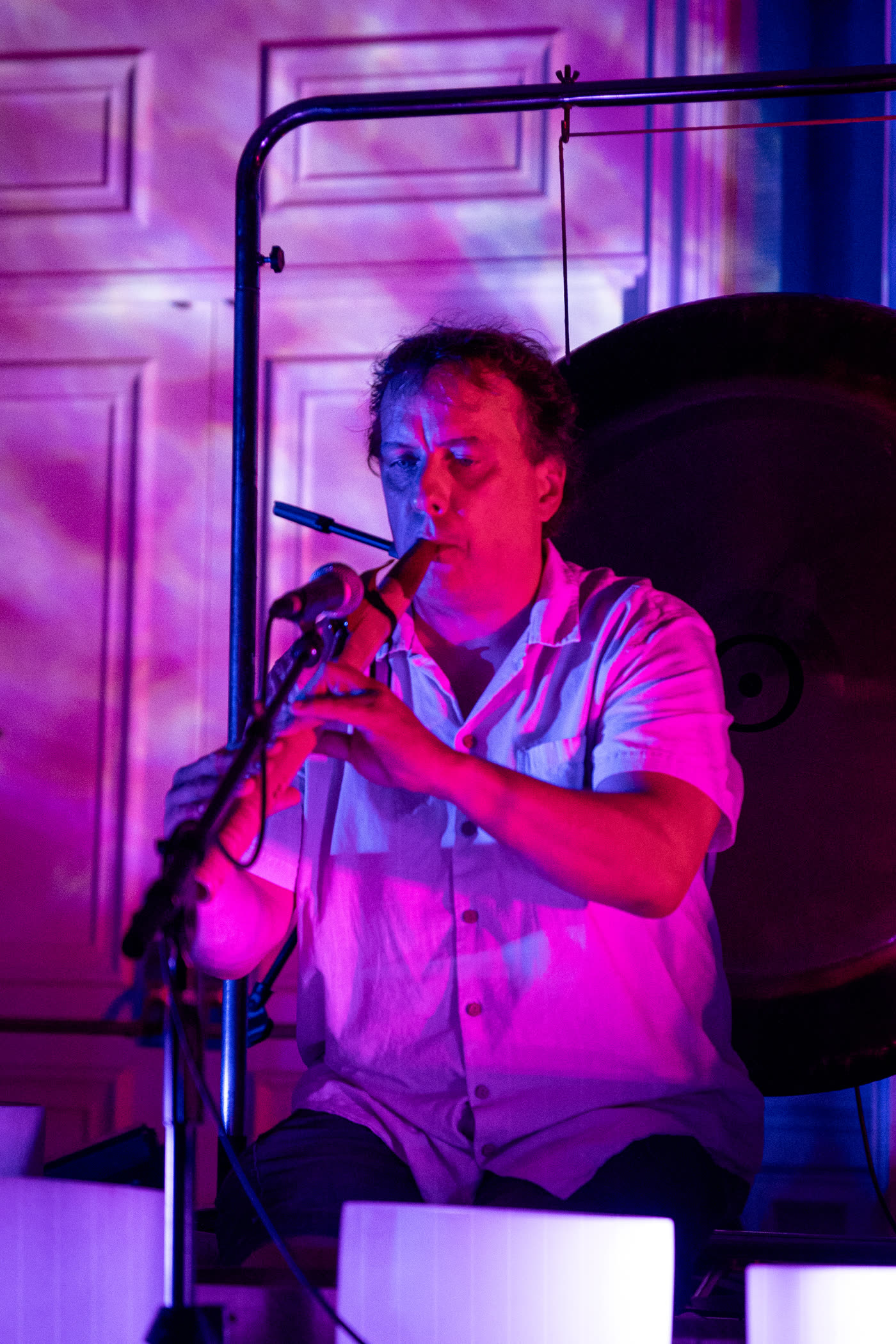 Guy playing the Native American flute in purple stage light