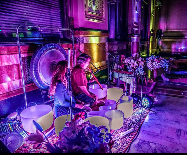 Musicians playing crystal singing bowls and a gong