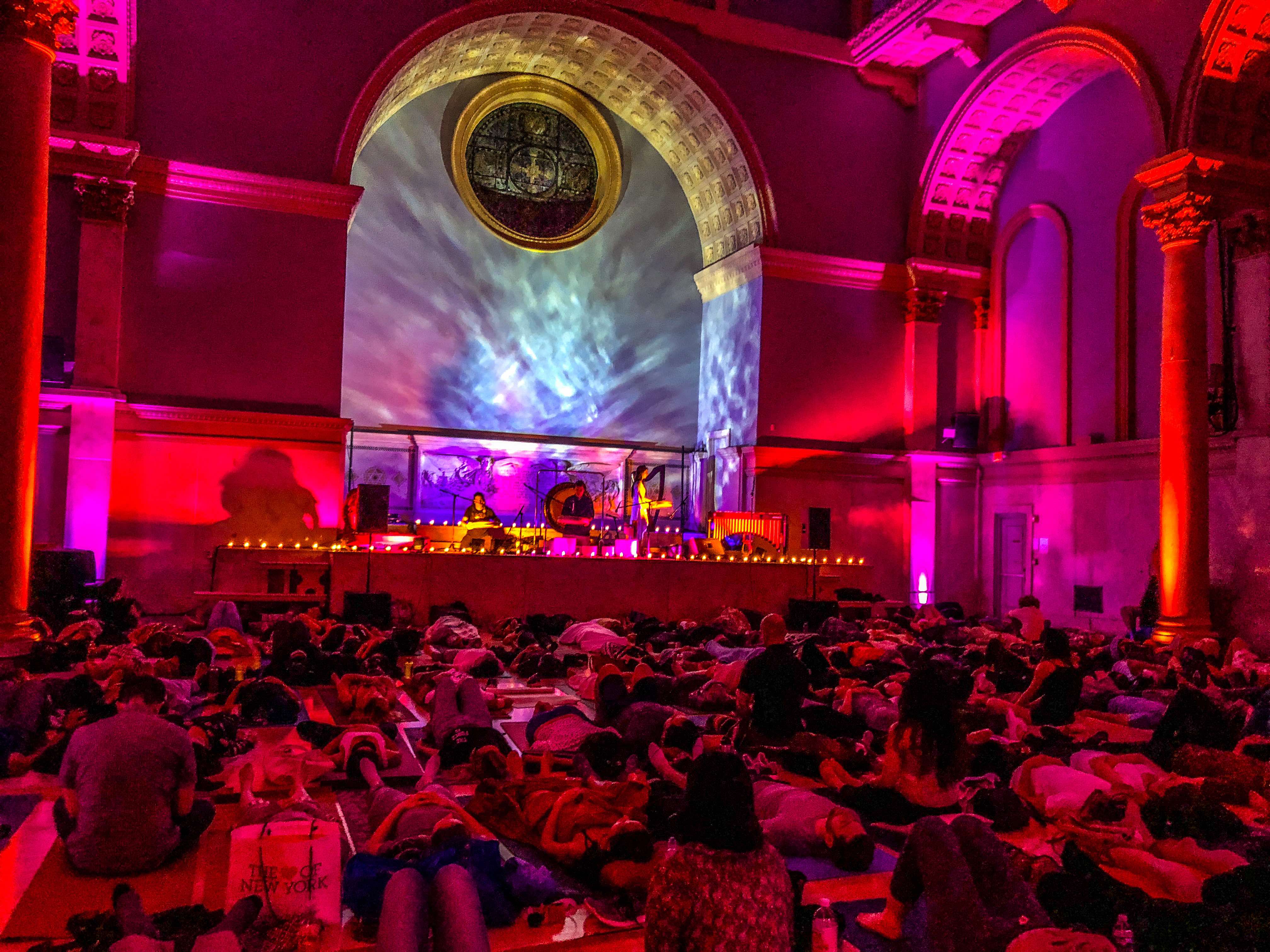 Large crowd lying down on mats at a sound healing event