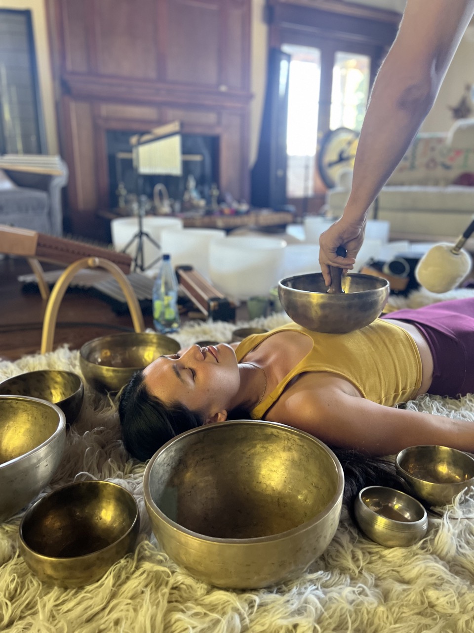 Tibetan singing bowls placed around a resting student during training