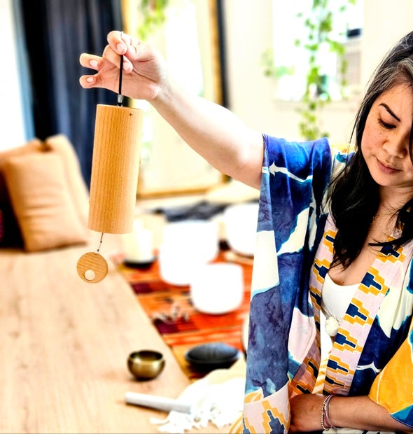 Practitioner holding a chime during a sound bath